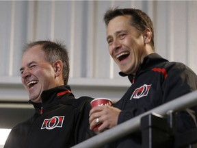 Senators general manager Pierre Dorion, left, and head coach Guy Boucher share a lighter moment during a training camp practice in mid-September. Tony Caldwell/Postmedia