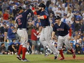 Mitch Moreland of the Boston Red Sox celebrates with Xander Bogaerts and Brock Holt after Moreland hit a three-run home run in the seventh inning against pitcher Ryan Madson of the Los Angeles Dodgers (not in photo) in Game 4of the 2018 World Series at Dodger Stadium on Oct. 27, 2018 in Los Angeles.