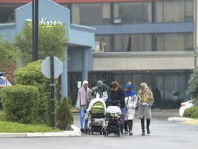 A group of women watch their children outside the Radisson hotel at Hwy 401 and Victoria Park Ave. in North York on Tuesday. (Jack Boland/Toronto Sun)