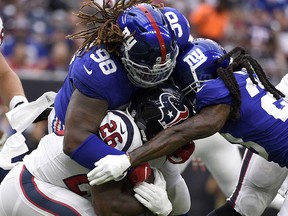 In this Sept. 23, 2018, file photo, Houston Texans running back Lamar Miller (26) is tackled by New York Giants' Damon Harrison Sr. (98) and B.W. Webb (23) in Houston. (AP Photo/Eric Christian Smith, File)