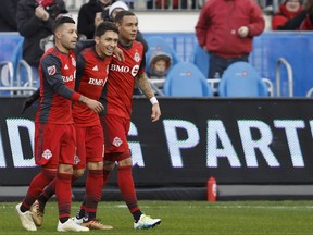 Toronto FC midfielder Marco Delgado (18) celebrates a goal against the Atlanta United alongside forward Lucas Janson, left, and Toronto FC defender Gregory van der Wiel (9) during the first half of MLS soccer action in Toronto, Sunday, Oct. 28, 2018. THE CANADIAN PRESS/Cole Burston