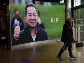 A man leaves the Leicester City fan store with a big screen showing a tribute to the club's Thai chairman Vichai Srivaddhanaprabha, who died in a helicopter crash at the club's King Power Stadium on Saturday. (Getty Images)