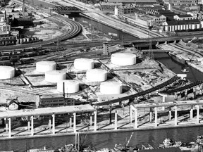 The Toronto Telegram newspaper’s photographer Les Baxter specialized in aerial photos. This one was among many he took in Feb. 1963 and shows work on the Gardiner Expressway at the mouth of the Don River. At the bottom of the view is the Keating Channel that forms the outlet of the Don River. The river itself terminates at the bottom right of the view where it enters the man-made watercourse named in honour of city engineer Edward Keating, who proposed the channel’s creation in 1893 as a way of diverting the mouth of the Don River westerly allowing it to empty into the harbour instead of continually polluting the delta and marshlands that had formed over hundreds of years at the original mouth of the river in what is now the Port Lands. Just north of the channel, we can see one of the elevated sections of the new Lakeshore Expressway (it wouldn’t get the Frederick Goldwyn Gardiner title until the following year) with the nice, clean support pillars and related curved sections that would eventually connect the new Lakeshore Expressway with the future Don Valley Parkway taking shape. Construction of the Parkway was still some years in the future. At the extreme bottom right is the Lakeshore Expressway Eastern Extension that was originally constructed as a connecting link with the still-to-be approved Scarborough Expressway. One idea that has been suggested during the run-up to tomorrow’s civic election is to demolish all that remains of this particular section and create a wide traffic boulevard instead. Moving north up the Don we see railway bridges at the south end followed by the original, and now closed, Eastern Ave. bridge and its nearby enclosed neighbour that still carries Consumers’ Gas pipelines over the river. Next, are the Queen St., Dundas St. and Gerrard St. bridges. North and east of the latter bridge is the Don Jail, Riverdale Park and the Riverdale Hospital complex (now Bridgepoint Active Healthcare). In the distance is the Prince Edward Viaduct.

 Other now demolished buildings in the view include the former Davies meat packing plant (its enormous pig processing activities gave rise to one of our city’s epithets “Hogtown”) on Front St. close to the Don, land under consideration for development as Ataratri, a mix of subsidized and market priced housing and at the extreme right the Lever Brothers industrial complex.