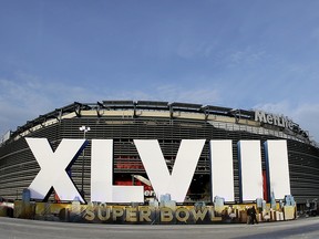 In this Feb. 1, 2014, file photo, a sign for Super Bowl XLVIII stands in front of MetLife Stadium in East Rutherford, N.J. (AP Photo/Charlie Riedel, File)