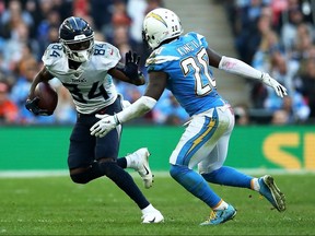Titans wide receiver Corey Davis (84) fends off Chargers defender Desmond King (20) during the NFL International Series game at Wembley Stadium in London, England, Sunday, Oct. 21, 2018.