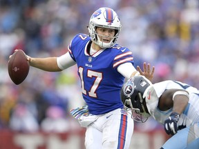 Buffalo Bills quarterback Josh Allen, left, tries to avoid a tackle from Tennessee Titans linebacker Sharif Finch during the second half of an NFL football game, Sunday, Oct. 7, 2018, in Orchard Park, N.Y. (AP Photo/Adrian Kraus)