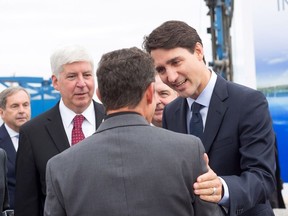 Prime Minister Justin Trudeau and Michigan Governor Rick Snyder greet Dr. Murray Howe, Gordie Howe's son, in Windsor, Ont., Friday, Oct. 5, 2018. The federal government says the Gordie Howe Bridge, a multibillion-dollar construction project to build a link between Detroit and Windsor, is officially underway.
