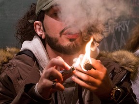 A cannabis-connoisseur blazes one in Toronto on Wednesday, celebrating Canada's legalization of recreational marijuana.  (Craig Robertson/Toronto Sun)