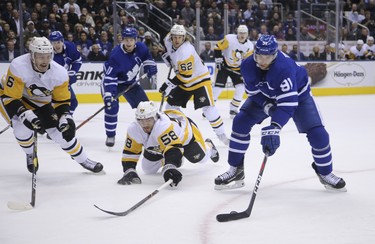 Toronto Maple Leafs John Tavares C (91) looks for wiggle room against Pittsburgh Penguins Kris Letang D (58) during the first period in Toronto on Thursday October 18, 2018. Jack Boland/Toronto Sun/Postmedia Network