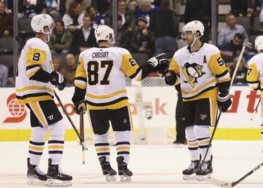 Pittsburgh Penguins Sidney Crosby C (87) celebrates teammate Pittsburgh Penguins Kris Letang D (58) 100th NHL goal - an empty netter - during the third period in Toronto on Thursday October 18, 2018. Jack Boland/Toronto Sun/Postmedia Network