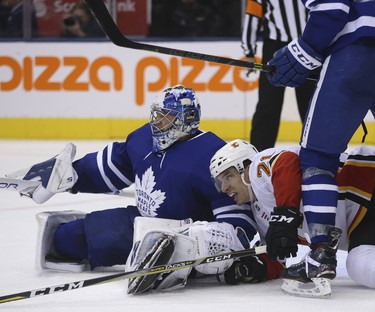 Calgary Flames Garnet Hathaway RW (21) is checked into Toronto Maple Leafs Frederik Andersen G (31) during the second period in Toronto on Tuesday October 30, 2018. Jack Boland/Toronto Sun/Postmedia Network