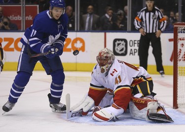 Toronto Maple Leafs Zach Hyman C (11) tries to swat the puck out of the air in front of Calgary Flames Mike Smith G (41) during the third period in Toronto on Tuesday October 30, 2018. Jack Boland/Toronto Sun/Postmedia Network