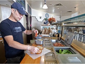 Deja Vu Cafe owner Mike Chung serves up his signature BLT sandwich after finding out that his restaurant will be allowed to stay, instead of Metrolinx putting in a Tim Hortons, and closing his restauraunt in Ajax on Tuesday October 9, 2018. Dave Abel/Toronto Sun/Postmedia Network