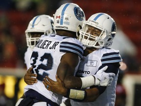 Argonauts' quarterback James Franklin (right) celebrates his touchdown with teammate James Wilder Jr., during a recent game against the Calgary Stampeders. (THE CANADIAN PRESS)