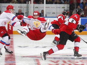 A Russian player goes flying during the game against Team Canada in Oshawa last night.  Ian Goodall/Goodall Media Inc