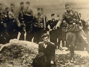 The photo taken between 1941 and 1943 near Vinnitsa, Ukraine, provided by the U.S. Holocaust Memorial Museum shows German soldiers of the Waffen-SS and the Reich Labour Service looking on as a member of an Einsatzgruppe prepares to shoot a Ukrainian Jew kneeling on the edge of a mass grave filled with corpses.