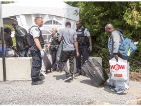 A group of asylum seekers cross the Canadian border at Champlain, N.Y., Friday, August 4, 2017. Prime Minister Justin Trudeau, long an outspoken champion of Canada's reputation for welcoming newcomers, added a bracing dose of reality Friday as he urged would-be migrants to respect the country's border with the United States.