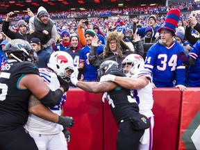 Carlos Hyde #34 of the Jacksonville Jaguars grabs the face mask of Star Lotulelei #98 of the Buffalo Bills as both teams scuffle during the third quarter at New Era Field on November 25, 2018 in Orchard Park, New York. Buffalo defeats Jacksonville 24-21.  (Photo by Brett Carlsen/Getty Images)
