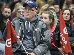 Robert Nichol, a 30-year employee at GM, and his daughter, a student employee for the company, listen at their union hall after GM announced it is closing up shop in Oshawa. (Craig Robertson, Toronto Sun)