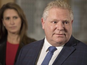 Ontario Attorney General Caroline Mulroney, left, looks on as Ontario Premier Doug Ford speaks to media following his meeting with Quebec Premier Francois Legault at Queens Park in Toronto on Nov. 19, 2018. (The Canadian Press)