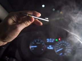 In this photo illustration, smoke from a cannabis oil vaporizer is seen as the driver is behind the wheel of a car in North Vancouver, B.C. (The Canadian Press)