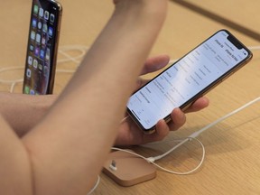 A customer looks at a new iPhone XS Max on display at an Apple store in New York on Friday, Sept. 21, 2018. (AP Photo)