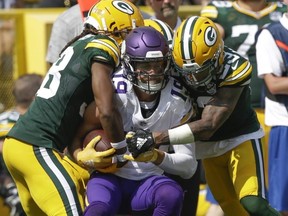 Vikings receiver Adam Thielen catches a pass between Packers defenders Tramon Williams and Jaire Alexander during NFL action in Green Bay, Wis., on Sept. 16, 2018.