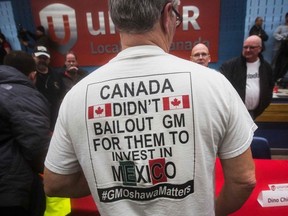 A worker wears a t-shirt during a information session at Local 222 in Oshawa, Ontario, on November 26, 2018. - In a massive restructuring, US auto giant General Motors announced it will cut 15 percent of its workforce to save $6 billion and adapt to "changing market conditions." The moves include shuttering seven plants worldwide as the company responds to changing customer preferences and focuses on popular trucks and SUVs and increasingly on electric models.  GM will shutter three North American auto assembly plants next year: the Oshawa plant in Ontario, Canada; Hamtramck in Detroit, Michigan and Lordstown in Warren, Ohio.