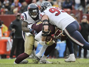 Washington Redskins quarterback Alex Smith ankle is injured as he is sacked by Houston Texans defensive end J.J. Watt  and Houston Texans strong safety Kareem Jackson during the second half of an NFL football game, Sunday, Nov. 18, 2018 in Landover, Md. (AP Photo/Mark Tenally)