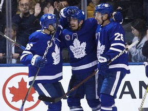 Maple Leafs forward Andreas Johnsson (centre) celebrates his first goal of the season with teammates Par Lindholm (left) and Connor Brown (right) during second period NHL action against the Devils in Toronto on Friday, Nov. 9, 2018.