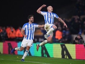 Huddersfield’s Aaron Mooy (right) celebrates after scoring his team’s second goal against the Wolves on Monday. Mooy scored twice, lifting Huddersfield into 15th place. (GETTY IMAGES)