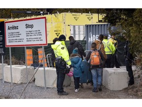 A family, claiming to be from Colombia, is arrested by RCMP officers as they cross the border into Canada from the United States as asylum seekers on April 18, 2018 near Champlain, N.Y.