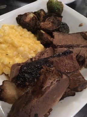 Juicy and tender smoked brisket with crispy brussels sprouts and creamy hominy make for a filling meal at 28 South in Hagerstown, Maryland. (Kevin Hann)
