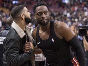 Miami Heat's Dwyane Wade, right, greets Drake following NBA basketball action against the Toronto Raptors in Toronto on Sunday, November 25, 2018. THE CANADIAN PRESS/Chris Young ORG XMIT: CHY109