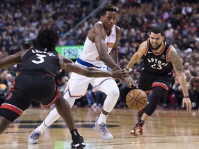 New York Knicks guard Frank Ntilikina (11) drives past Toronto Raptors forward OG Anunoby (3) and Raptors guard Fred VanVleet (23)during second half NBA basketball action in Toronto on Saturday, Nov. 10, 2018. THE CANADIAN PRESS/Nathan Denette ORG XMIT: NSD108