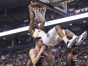 Toronto Raptors forward Kawhi Leonard hangs from the basket after scoring on the Washington Wizards during first half NBA basketball action in Toronto on Friday, November 23, 2018. THE CANADIAN PRESS/Chris Young ORG XMIT: CHY102