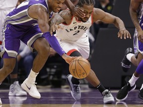 Sacramento Kings guard Buddy Hield, left, and Toronto Raptors forward Kawhi Leonard scramble for the ball during the second half of an NBA basketball game Wednesday, Nov. 7, 2018, in Sacramento, Calif. The Raptors won 114-105.  (AP Photo/Rich Pedroncelli) ORG XMIT: SCA310