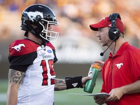Calgary Stampeders coach Dave Dickenson speaks with quarterback Bo Levi Mitchell (19) late in the second half CFL game action in Hamilton, Ont., on Saturday, September 15, 2018. (Peter Power/THE CANADIAN PRESS)