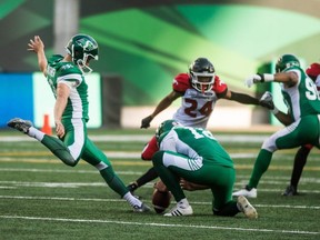 Roughriders' Brett Lauther (left) kicks a field goal during first half CFL action against the Stampeders, in Regina on Aug. 19, 2018.