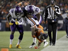 Chicago Bears wide receiver Taylor Gabriel is tackled by Minnesota Vikings cornerbacks Mackensie Alexander and Xavier Rhodes during the first half of an NFL football game Sunday, Nov. 18, 2018, in Chicago.