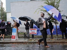 Voters line up in the rain outside Bright Family and Youth Center in the Columbia Heights neighborhood in Washington, Tuesday, Nov. 6, 2018. Across the country, voters headed to the polls Tuesday in one of the most high-profile midterm elections in years.