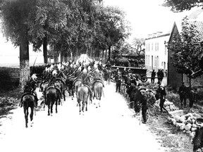 FILE - Lancers on horseback enter a Belgium village in the first days of the war on the Western Front in a 1914 photo. They were messengers, spies, sentinels and the heavy haulers of World War I, carrying supplies, munitions and food and leading cavalry charges. The horses, mules, dogs and pigeons were a vital part of the Allied war machine, saving countless lives _ and dying by the millions. (AP Photo, File)