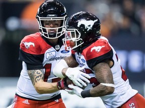 Calgary Stampeders quarterback Bo Levi Mitchell, left, hands off to Don Jackson during the second half of a CFL football game in Vancouver, on Saturday November 3, 2018.