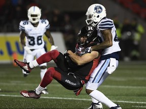 Ottawa Redblacks wide receiver Julian Feoli-Gudino (83) gets lifted off his feet by Toronto Argonauts defensive back Marcus Roberson Jr. (43) during first half CFL football action in Ottawa on Friday, Nov. 2, 2018. THE CANADIAN PRESS/Justin Tang