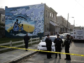 Police gather at the scene of a fatal shooting in a row home in Philadelphia, Monday, Nov. 19, 2018.
