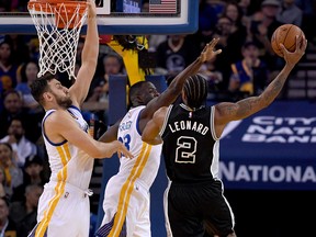 Kawhi Leonard, then of the San Antonio Spurs, shoots over Draymond Green (centre) and Andrew Bogut of the Golden State Warriors on April 7, 2016. (THEARON W. HENDERSON/Getty Images files)