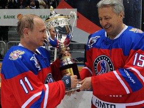 In this May 10, 2016, file photo, Russian President Vladimir Putin, left, is presented with a trophy by Night Hockey League president Alexander Yakushev after a gala match of the Night Hockey League in the Bolshoy Ice Dome in the Black Sea resort of Sochi, Russia. Yakushev was selected to the Hockey Hall of Fame, Tuesday, June 26, 2018. (Mikhail Klimentyev/Sputnik, Kremlin Pool Photo via AP, File)