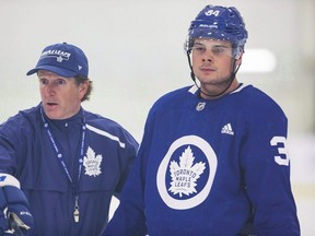 Toronto Maple Leafs coach Mike Babcock, left, explains a drill to Auston Matthews during training camp in Niagara Falls, Ont., September 16, 2018. Matthews gracing the cover of a fashion magazine. THE CANADIAN PRESS/Aaron Lynett
