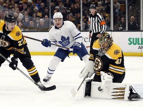 Bruins goaltender Jaroslav Halak, right, makes a save as Maple Leafs' Zach Hyman, centre, and Bruins defenceman John Moore (27) look for the rebound during first period NHL action in Boston, Saturday, Nov. 10, 2018.