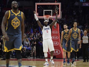 Los Angeles Clippers forward Montrezl Harrell, centre, celebrates as time runs out in overtime as Golden State Warriors forward Draymond Green, left, guard Klay Thompson, second from right, and guard Shaun Livingston walk off the court in an NBA game, Monday, Nov. 12, 2018, in Los Angeles.